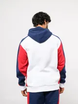 Campera deportiva Umbro del Club Nacional de Football, con cierre frontal, capucha ajustable con cordones y diseño en bloques de color azul, celeste y blanco. Presenta el logo de la marca y el escudo del club bordados en el pecho.