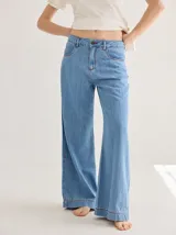 Pantalón de tiro medio alto, color azul claro, con bolsillos delanteros y traseros. Presenta detalles de atraques y triples costuras en color rojo. Confeccionado en una mezcla de lino y algodón.