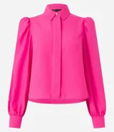 Camisa celeste de crepé con cuello inglés, manga larga abullonada y abotonadura frontal.