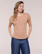 Remera de tejido acanalado color tostado, con escote redondo decorado con una hilera de tachas metálicas, mangas cortas estilo japonesa con dobles y ruedo curvo.