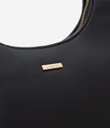Cartera baguette de cuero sintético marrón, con cierre de cremallera, asa ajustable y detalles metálicos en tono dorado claro.