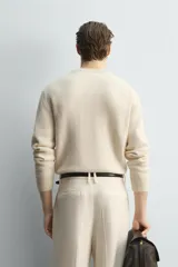 Jersey de punto relaxed fit confeccionado en mezcla de lana y fibra de alpaca, con textura ligera y efecto pelo. Presenta cuello redondo, manga larga y acabados en rib en puños y cintura.