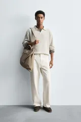 Polo de punto regular fit en color beige, confeccionado con una mezcla de algodón y cáñamo. Presenta cuello solapa con abertura frontal, manga larga y acabados en rib.