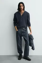 Bota de cuero negro con cordones tipo derby, parte superior lisa y plantilla interior de piel. Presenta horma cuadrada y suela con ligero tacón.