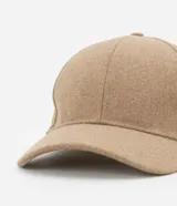 Gorra de feltro con ala curva y ajuste trasero mediante velcro. Diseño liso y minimalista.