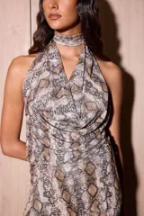 Top de microtul con estampado de reptil, de corte fluido y cuello halter. Presenta un diseño versátil y reversible con caída drapeada en el pecho y un ajuste suelto ideal para el verano.