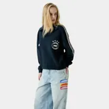 Polo de manga larga color azul marino con cuello clásico, diseño holgado y bandas laterales con estampado en las mangas. Presenta logo bordado en el pecho.