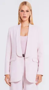 Blazer de sastrería color rosado con diseño estructurado, cuello solapa redondeado y cierre frontal con broche metálico. Cuenta con bolsillos laterales con solapa y un bolsillo superior decorativo.