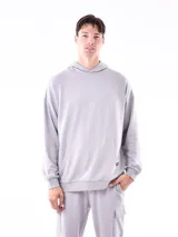 Hoodie de algodón color gris claro, con capucha, bolsillo canguro frontal y puños y cintura acanalados. Presenta un pequeño bordado en el pecho y en el bolsillo del pantalón que acompaña el conjunto.