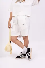 Bermuda negra de corte holgado con cintura elastizada y logo estampado en blanco en la pierna izquierda.