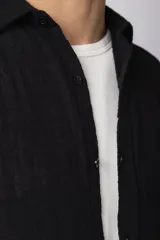 Camisa de manga larga confeccionada en tejido de lino con textura, de corte holgado y diseño versátil con cierre frontal de botones.