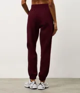 Pantalón jogger deportivo color bordó, con cintura elástica, bolsillos laterales y puños ajustados. Presenta recortes canelados en los laterales que aportan textura y diseño al modelo.