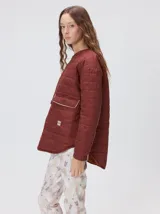 Campera reversible capitoneada con cierre frontal. Un lado es de color negro y el otro es de color beige, ambos con diseño acolchado. Cuenta con cuello redondo, mangas largas y bolsillos laterales.