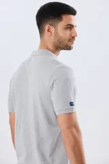 Remera polo lisa de piqué en color bordó, con cuello camisero, cierre frontal con botones y mangas cortas.