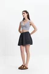 Minifalda negra con cintura elástica y volados en capas.