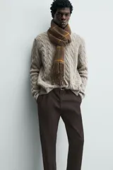 Pantalón chino de corte ajustado, color beige, con bolsillos laterales y bolsillos traseros de vivo. Cuenta con cierre frontal de cremallera y botón.