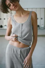 Top de punto color gris melange, con escote redondo, tirantes anchos y cierre frontal con botones.