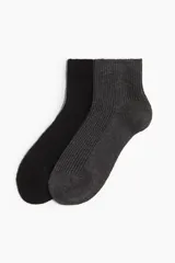 Pack de dos pares de medias tobilleras de punto acanalado, una en color negro y otra en color gris oscuro, confeccionadas con lana.
