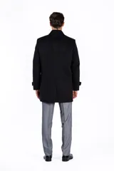 Abrigo clásico de paño azul marino, con cuello solapa, cierre frontal con botones y bolsillos laterales.