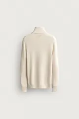 Jersey de punto perlado en color azul marino, con cuello perkins y cierre frontal de cremallera. Presenta manga larga y acabados en rib en puños y bajo.