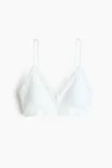 Soutien tipo Bralette color blanco de punto suave y diseño seamless, con breteles ajustables y ribete de encaje en los bordes. Copas con relleno extraíble, sin aros ni cierre.
