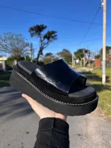 Ojota urbana de cuero con plataforma corrida marrón y faja ancha en color blanco con textura símil cocodrilo y separación para el dedo.