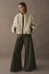 Campera tipo bomber de textura afelpada en color negro, con cierre frontal, cuello alto y puños y ruedo elásticos en cuero.