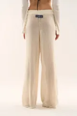 Pantalón tejido de punto color crema, de corte recto y holgado, con cintura elástica ajustable mediante cordón.