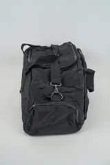 Bolso de viaje color negro con múltiples compartimentos con cierre, doble asa de mano y correa ajustable para el hombro.