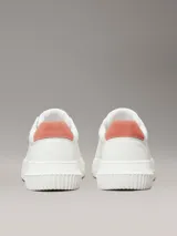 Zapatillas urbanas Calvin Klein de cuero blanco con logo CK en el lateral y detalle de gamuza color salmón en el talón.
