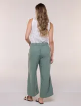 Pantalón crop de lino y rayón, con diseño wide leg de corte holgado, estampado tropical de hojas en tonos verde, azul y marrón sobre fondo blanco. Cuenta con pretina trasera elastizada y bolsillos delanteros.