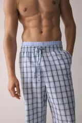 Pantalón de popelina de algodón a cuadros en tonos celeste, blanco y azul marino. Presenta cintura elástica con cordón ajustable, cierre decorativo y bolsillos laterales. Corte relajado.