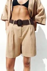 Bermuda de tiro alto color azul marino, con pinzas delanteras, bolsillos laterales y cinturón trenzado color marrón.