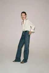 Camisa blanca ZARA Woman Collection de 100% seda, con escote en V ajustable con cordones entrelazados y manga larga con puños rectos.
