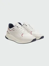 Zapatillas deportivas Boss modelo TTNM EVO, color blanco con detalles en azul marino y rojo. Presentan una combinación de paneles de cuero sintético perforado y malla transpirable, con suela de goma robusta y logo de la marca en el lateral.