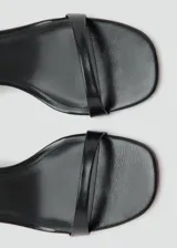 Sandalia de tacón bloque color negro, con diseño de tira delantera y cierre de pulsera al tobillo con hebilla metálica.