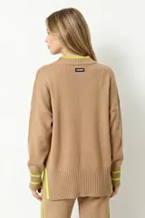 Sweater oversize de tejido rib color beige, con cuello redondo y detalles en color verde lima en el cuello, puños y aberturas laterales.