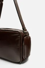 Bandolera marrón de piel con acabado envejecido, compartimento principal con cierre de cremallera, bolsillo interior plano y con cremallera, dos bolsillos frontales con botón a presión, dos bolsillos laterales con cremallera y asa de hombro ajustable.