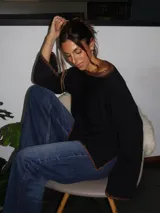 Sweater tejido de punto jersey en color negro, con terminaciones hechas a mano en crochet a contratono con detalles de lurex. Presenta una silueta oversize, mangas acampanadas y cuello a la base.