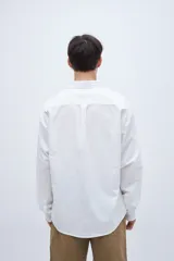 Camisa celeste de algodón, corte regular fit, con cuello solapa clásico, manga larga, bolsillo en el pecho y botones personalizados.