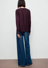 Blusa de viscosa color bordó, con escote en V y cierre de lazo, de manga larga con puños abotonados y diseño recto.