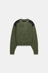 Jersey de punto de cuello redondo y manga larga, con diseño de textura acanalada en color verde oliva y detalles de paneles en color gris oscuro en los hombros.