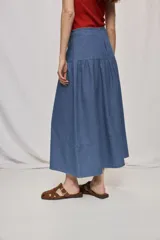 Falda midi de denim color beige, con diseño de volados y caída fluida.
