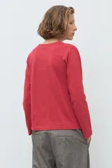 Remera de manga larga color rojo, con cuello redondo y detalle de bordado floral en el pecho.