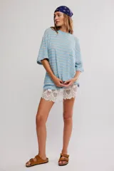 Remera oversize de manga corta a rayas celestes y blancas, con cuello redondo y un bolsillo aplicado en el pecho.