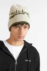 Gorro de invierno reversible Quiksilver, color verde militar con inscripción de la marca en color blanco y una pequeña etiqueta roja con el logo.