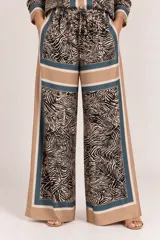 Palazzo de satén de pierna ancha, con cintura elástica con cordón de ajuste, diseño estampado con combinación de animal print y paneles geométricos en tonos camel, azul y negro.