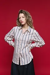 Camisa de algodón celeste con rayas verticales azul marino y marrón, cuello camisero clásico y cierre frontal de botones nacarados.