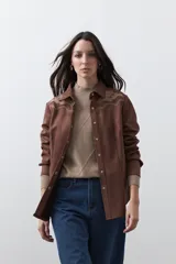 Sobrecamisa de gamuza color marrón con bordados decorativos estilo western en la zona de los hombros y cierre frontal con botones metálicos.