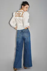 Jean de corte oxford y tiro medio, confeccionado en denim de color azul clásico. Presenta un diseño de pierna ancha y holgada, con cierre frontal y bolsillos laterales y traseros.